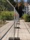 Der Bauzaun lässt gerade noch einen Weg am Gebäude entlang frei.